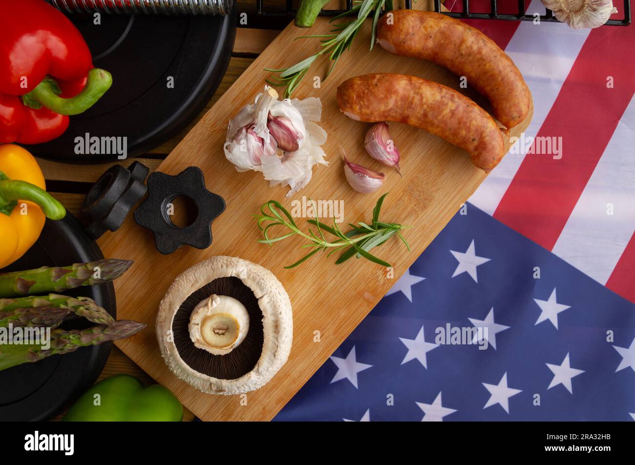 Gym Kurzhanteln, Essen und Flagge der Vereinigten Staaten von Amerika. Fit Barbecue-Party-Konzept für die Feiertagsfeier am 4. Juli in den USA. Stockfoto