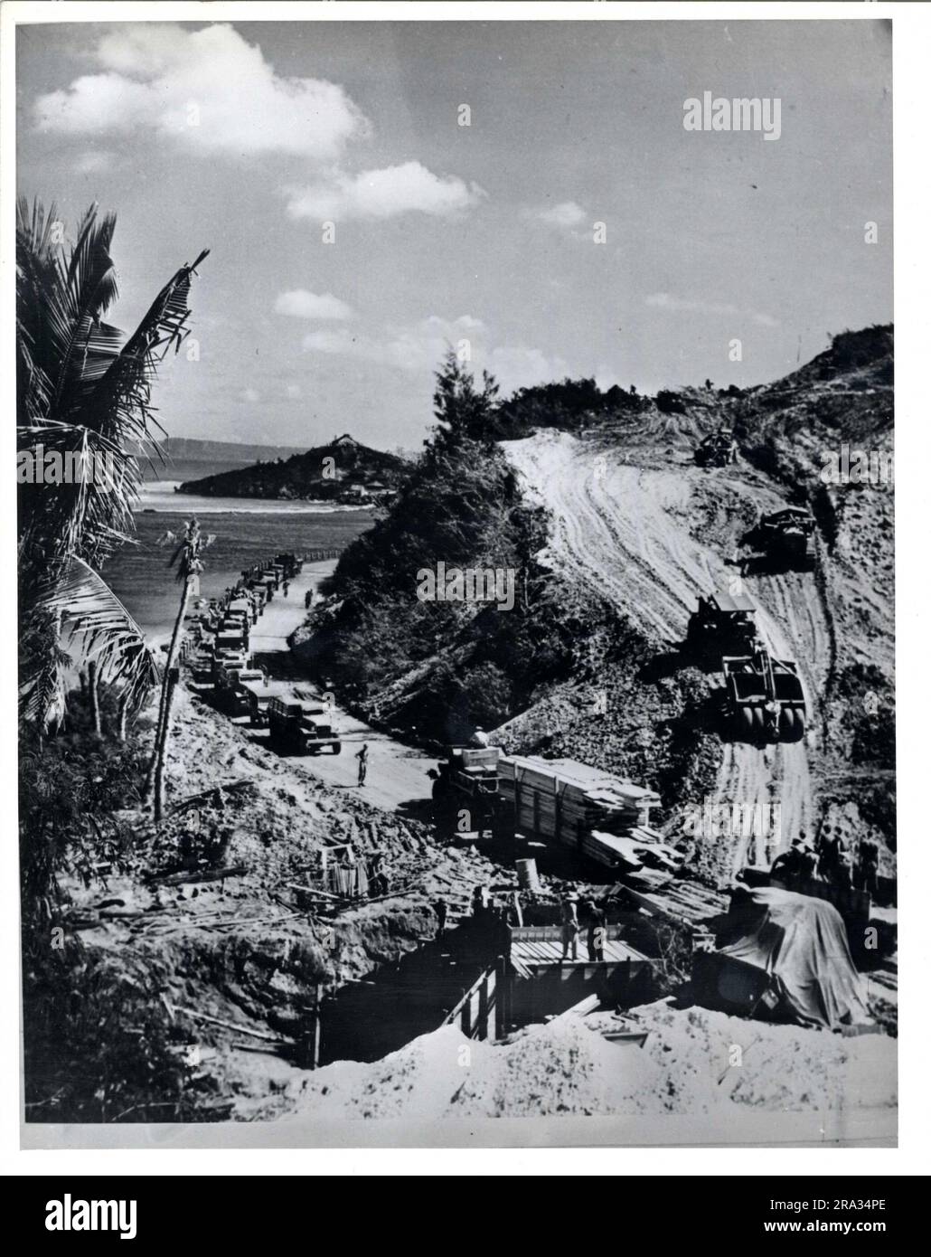 Kurven werden hier nicht berücksichtigt. SeaBees auf Guam folgten zunächst dem einfachsten Weg, um schnell eine nutzbare Straße zu schaffen. Hier entfernen sie einen Teil eines Berges, um eine Kurve vor dem Pflaster zu entfernen. 1946-01-01T00:00:00. Stockfoto