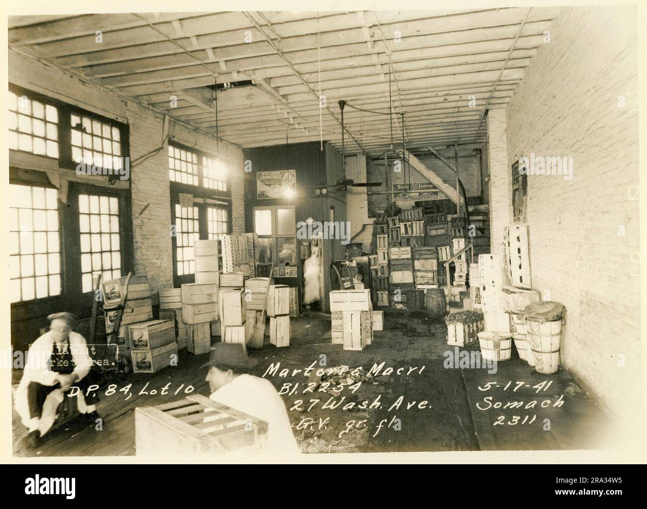 Foto von Interior Wallabout Market, D.P. 84, Los 10, Bl. 2254, 27 Wash. Ave. Martori & Macri G. V. gr. fl... Blick auf den großen Raum mit Bürotrennwand, Kisten und 2 Mann, mit Fensterdetails, vom Negativen 2311.. Stockfoto