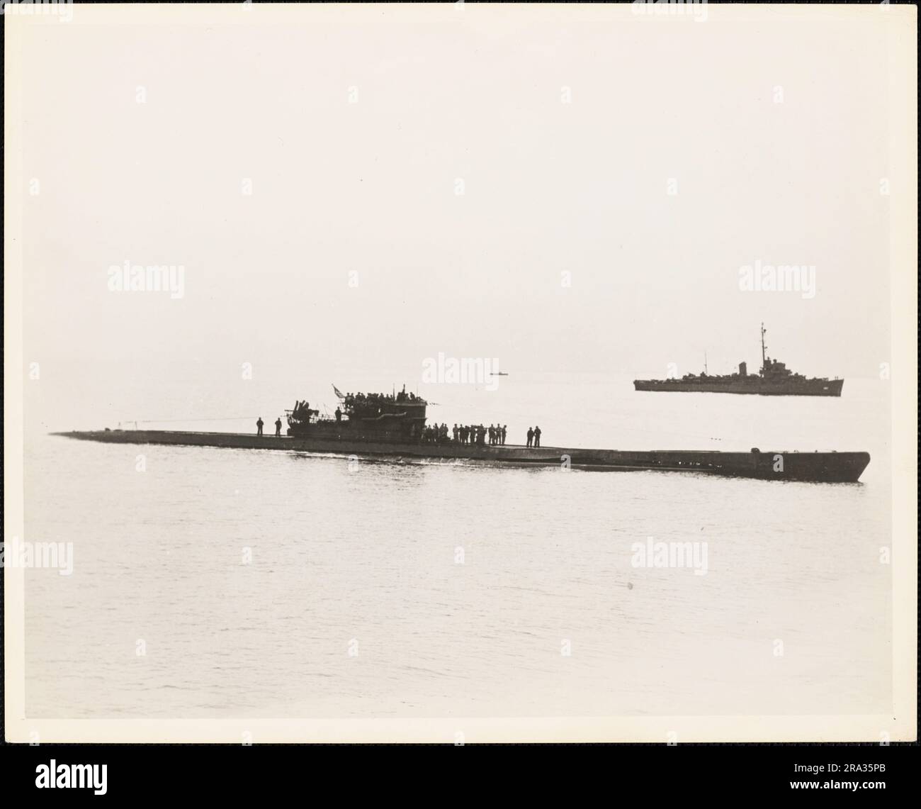 Hat Kriegsmarine U-1228 aufgegeben, die unter Escort nach Portsmouth, New Hampshire kommt. Dieses Foto zeigt das deutsche U-1228-U-Boot, das nach Portsmouth, New Hampshire, einfährt, wo sie sich am 17. Mai 1945, zehn Tage nach der Kapitulation Deutschlands, die den Zweiten Weltkrieg in Europa und dem Atlantik beendete, den US-Streitkräften stellte. 1945-05-17T00:00:00. Nordostregion (Boston, MA). Fotodruck. Abteilung der Marine. Erster Marinebezirk. Büro des stellvertretenden Stabschefs für Verwaltung. Büro des Historischen Offiziers. Ca. 1941-ca. 1946. Verwaltungsgeschichte der ersten Marine Stockfoto