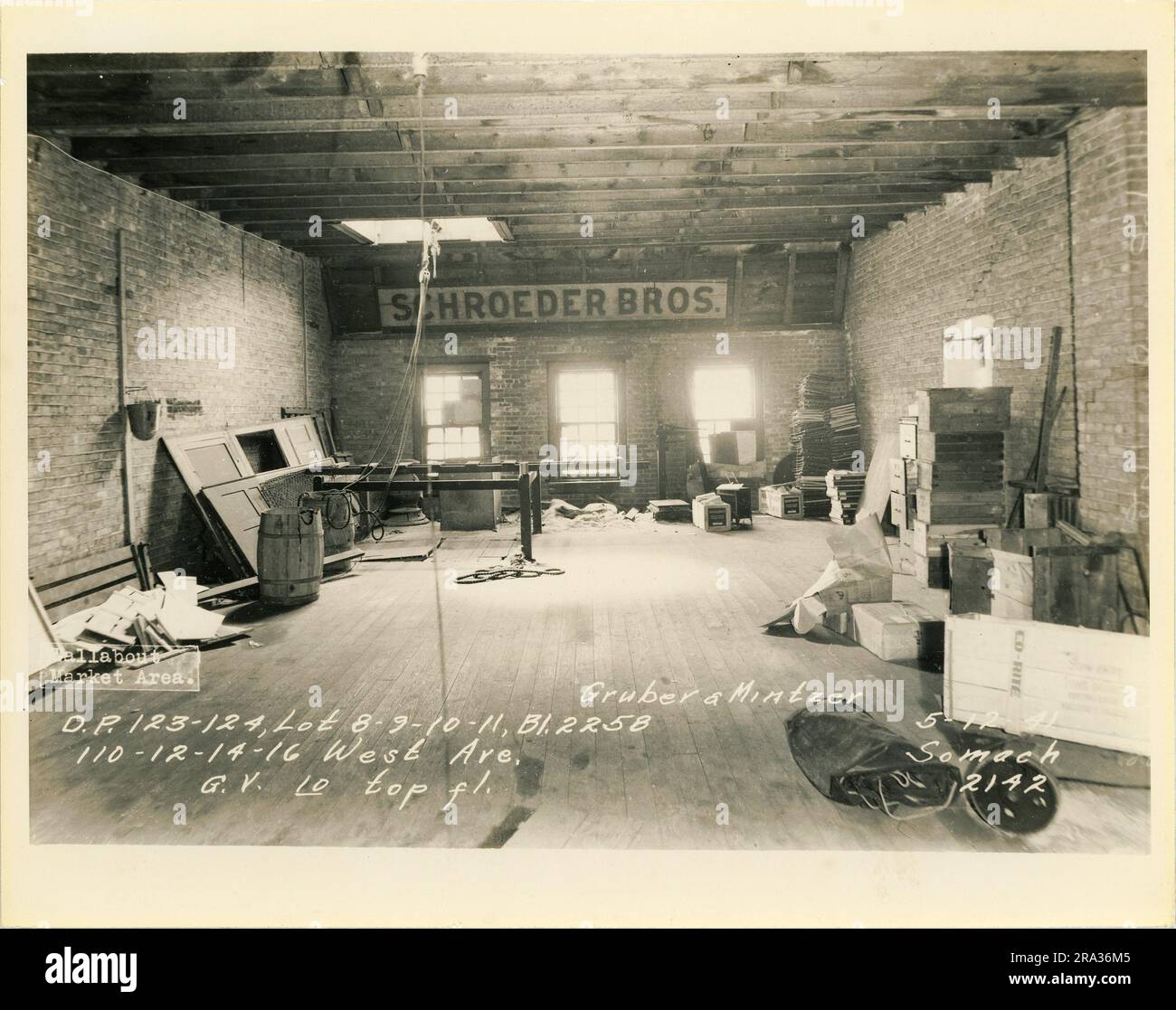 Foto des Innenraums der Lose 8-9-10-11, Bl. 2258, 110-12-14-16 West Ave, oberste Etage von Gruber & Mintzer, D.P. 123-124. Zeigt das Innere mit einem Schild für Schroeder Bros an der Wand. Stockfoto