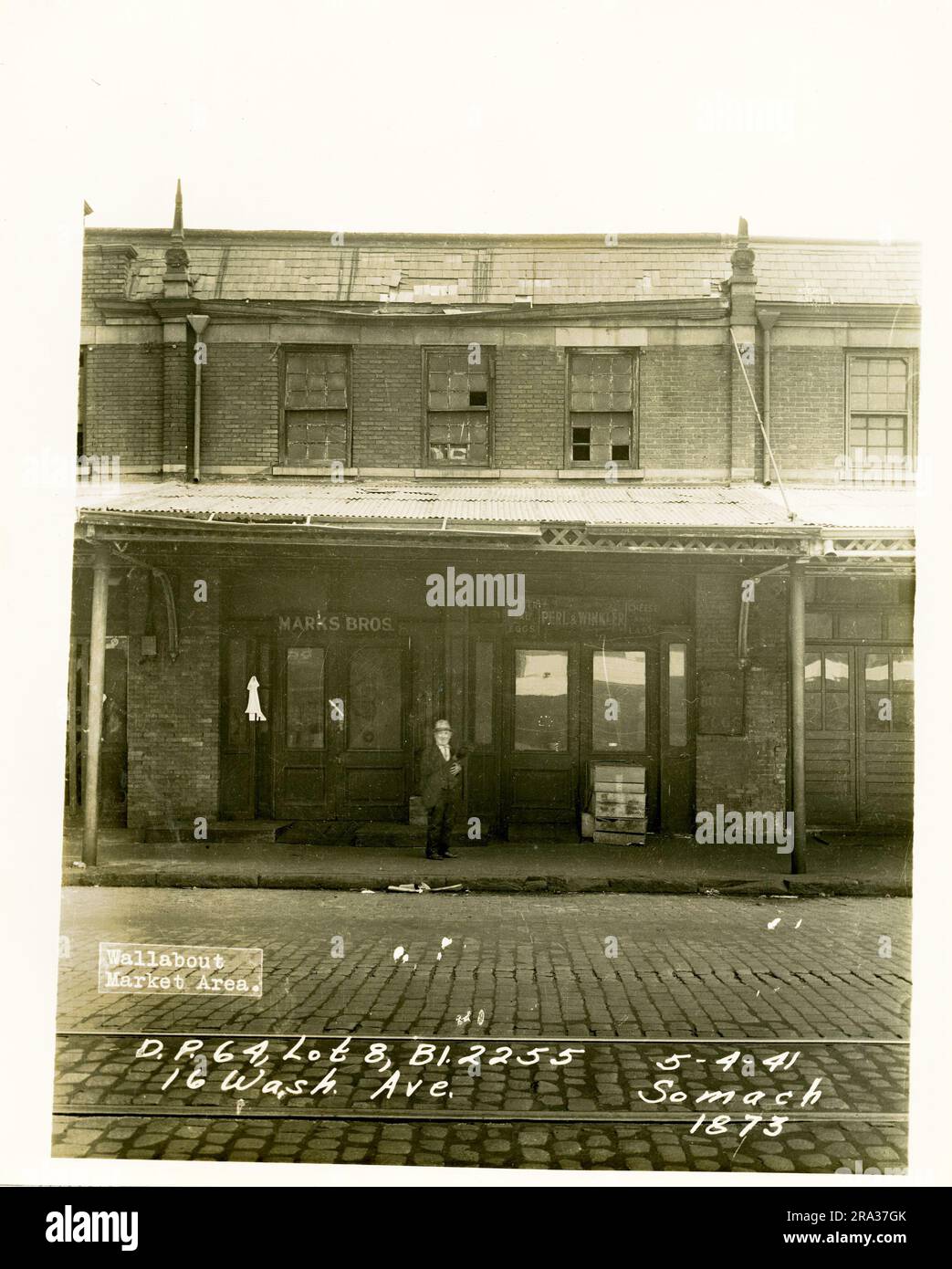 Foto: Wallabout Market, D.P. 64, Los 8, Bl. 2255, 16 Washington Ave. Vorderansicht der Eingänge von Marks Bros. Und Perl & Winkler Store, mit Mann mit Hut in der Mitte, vom Negativ 1873... Stockfoto