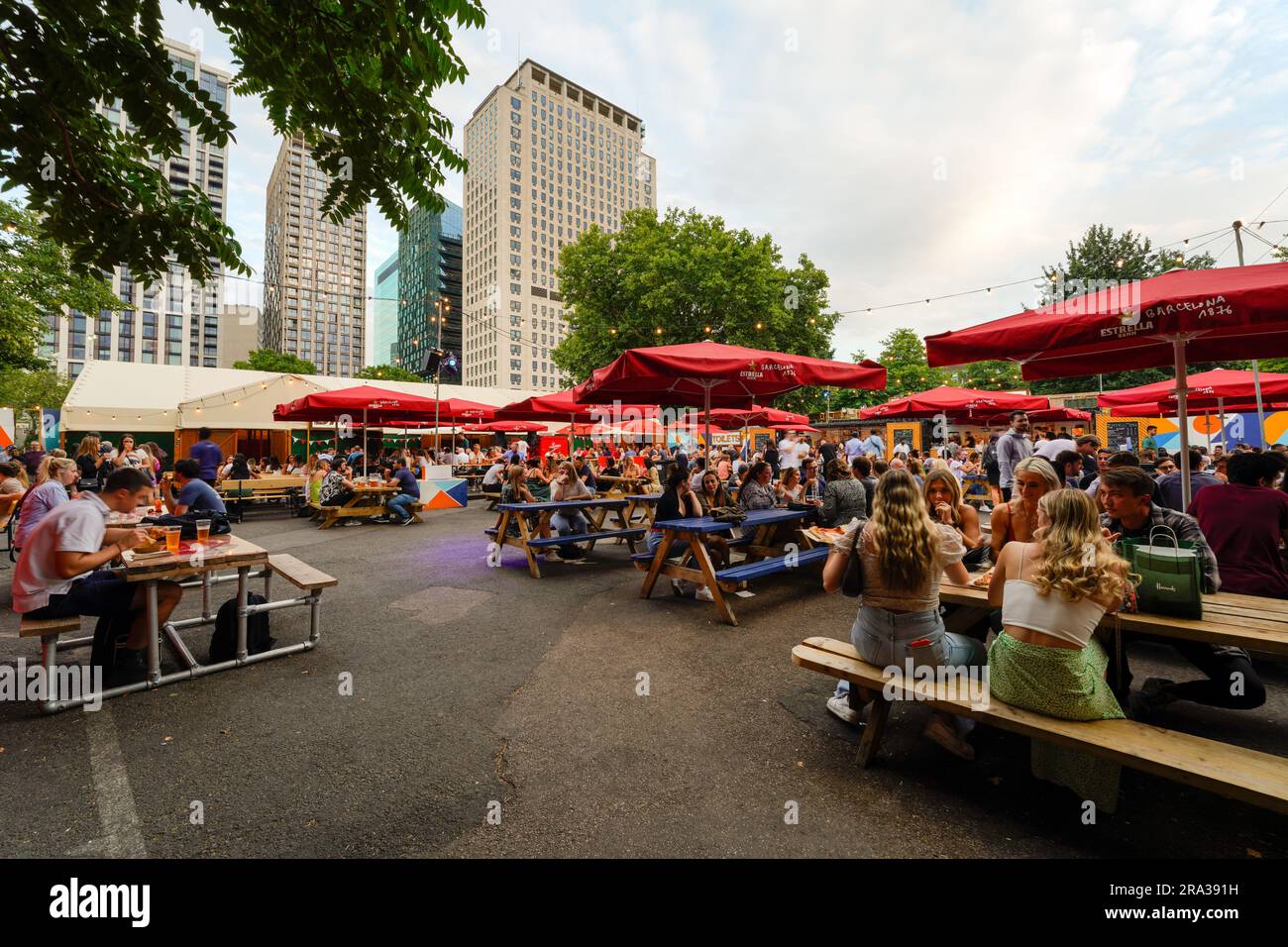 Leute, die sich in einem Restaurant im Freien unterhalten, zwischen den Brücken, an der Themse. Es ist einer der größten Veranstaltungsorte im Freien in London City. Stockfoto