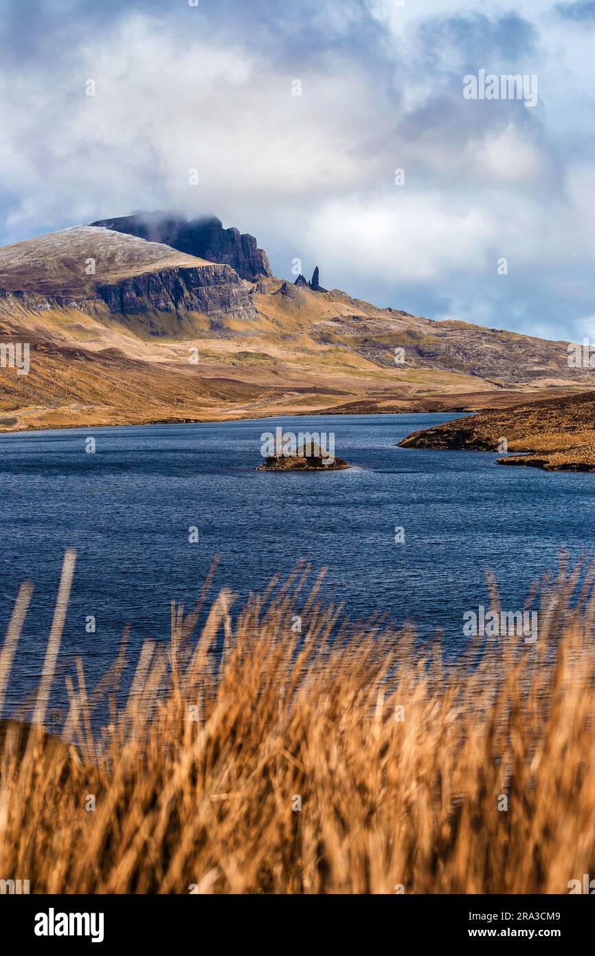 Isle of Skye, Schottland - das wunderschöne Loch Fada (See Fada) und die schneebedeckten Gipfel des Old man of Storr an einem sonnigen Frühlingsmorgen mit blauem Himmel und Wolken Stockfoto