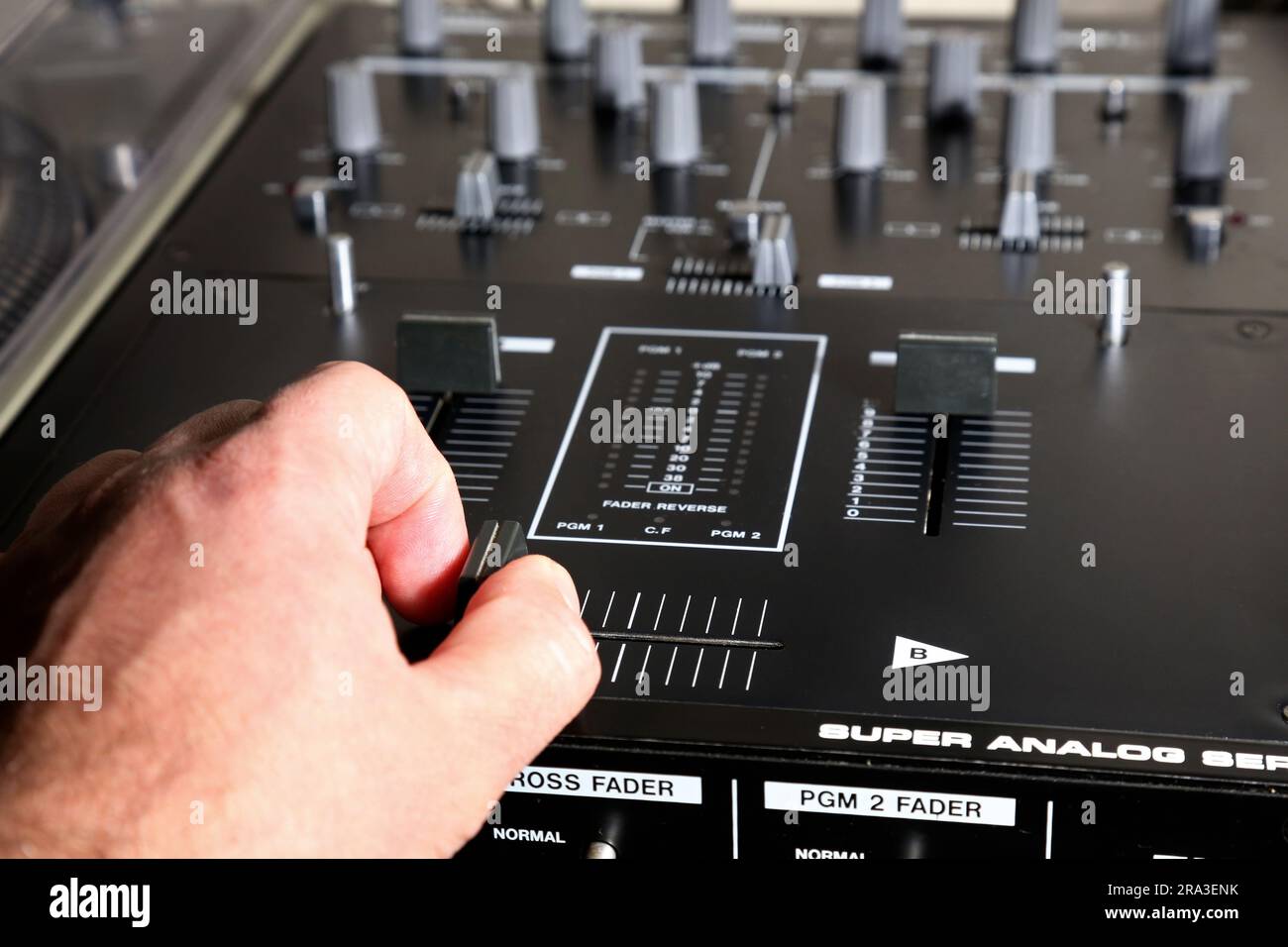 DJ-Mixer Nahaufnahme mit Hand (super analog mit Crosfader) Lautstärkeregler, audiophile Turntableist Equipment Vintage Stockfoto
