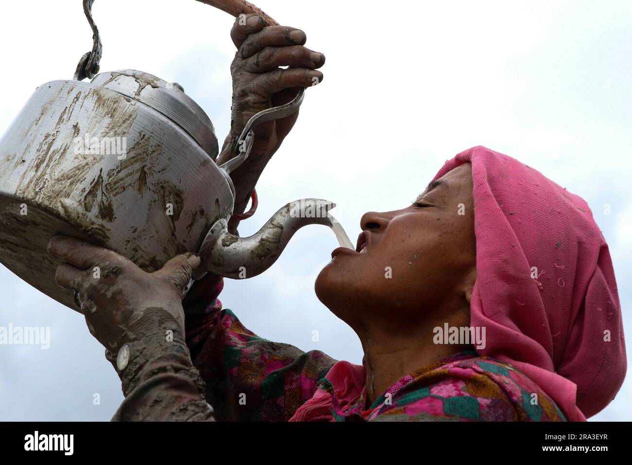 Kathmandu, Nepal. 30. Juni 2023. Am 30. Juni 2023 in Kathmandu, Nepal. Eine nepalesische Frau trinkt zu Hause und macht Reisbier während der Plantage, die mit dem "National Paddy Day" oder "Ashar Pandhra" gekennzeichnet ist. An diesem Tag essen die Nepalesen speziell Joghurt, indem sie gequetschten Reis mischen, traditionelle Lieder singen, hausgemachtes Reisbier trinken und im schlammigen Wasser spielen, während sie Reiskeimlinge auf ihren Feldern plattieren. (Abhishek Maharjan/Sipa USA) (Foto von Abhishek Maharjan/Sipa USA) Guthaben: SIPA USA/Alamy Live News Stockfoto