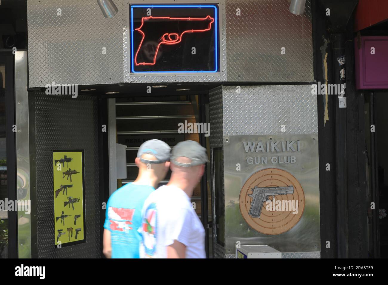 FILE People walk past a gun club on June, 23, 2022, in Honolulu