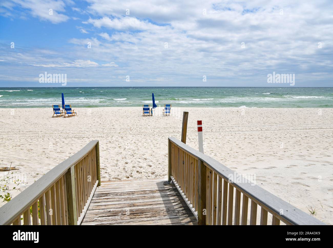 Blaue Strandstühle mit Sonnenschirm am weißen Sandstrand Stockfoto