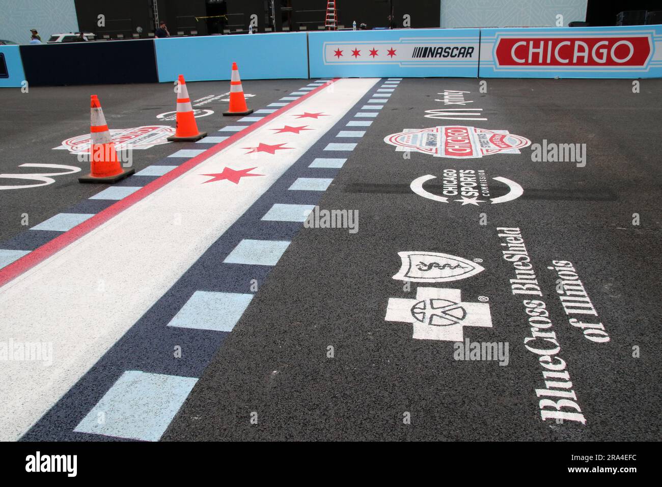 Das frisch gestrichene Logo, das für die Veranstaltung wirbt, und die Sponsorenlogos sind am 30. Juni 2023 auf der Rennstrecke in der Nähe der Startlinie im Millenium Park, Chicago, zu sehen. Heute feiert NASCAR sein 75.-jähriges Jubiläum und das erste Straßenrennen in der NASCAR Cup Series, das am 1-2 2023. Juli ausgetragen wird. Die Skyline von Chicago und der Lake Michigan bilden die Kulisse. (Foto: Alexandra Buxbaum/Sipa USA) Guthaben: SIPA USA/Alamy Live News Stockfoto
