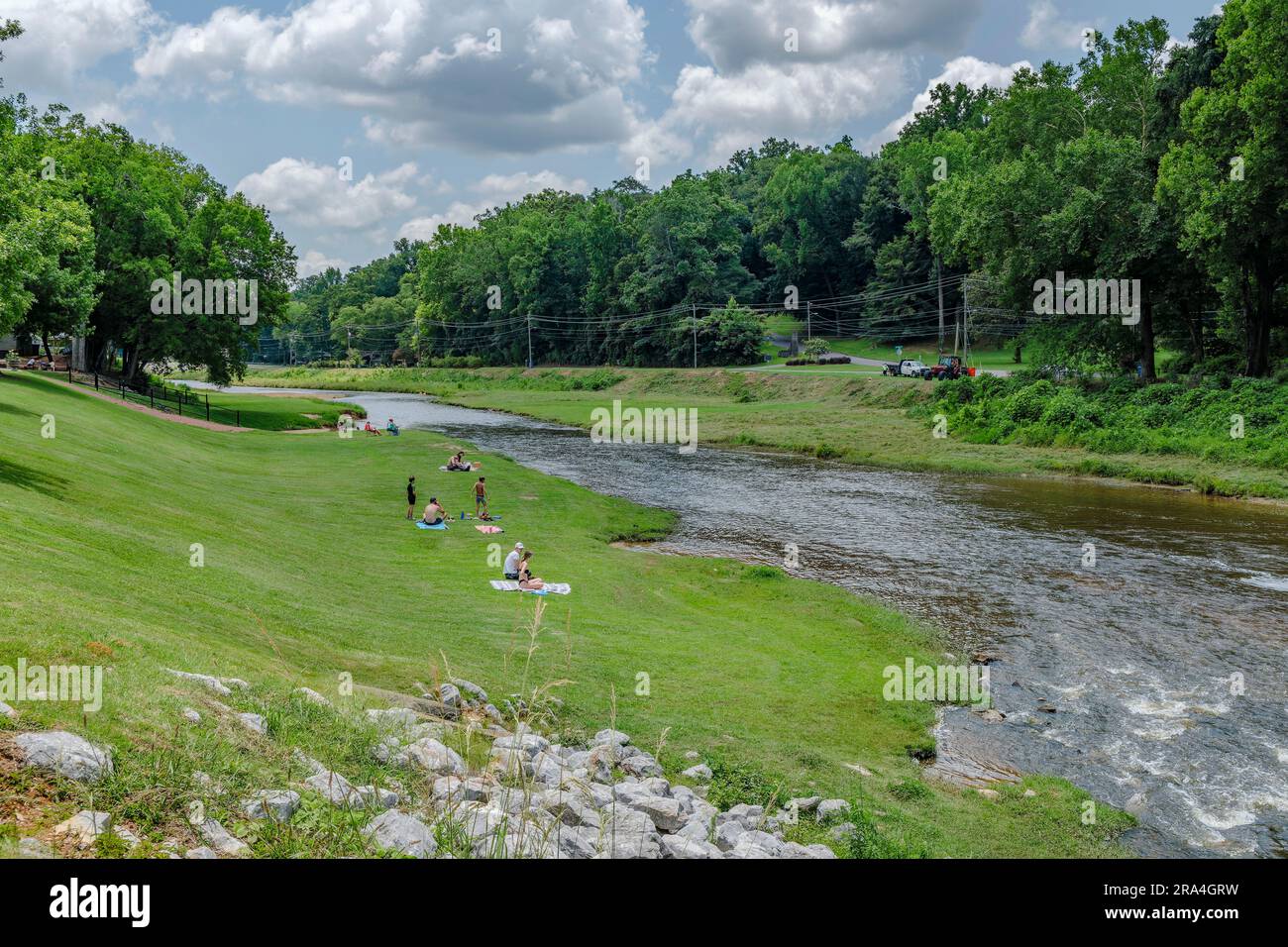 Familien entspannen sich am Autauga Creek und sonnen sich an einem heißen Sommertag in Prattville, Alabama, USA. Stockfoto
