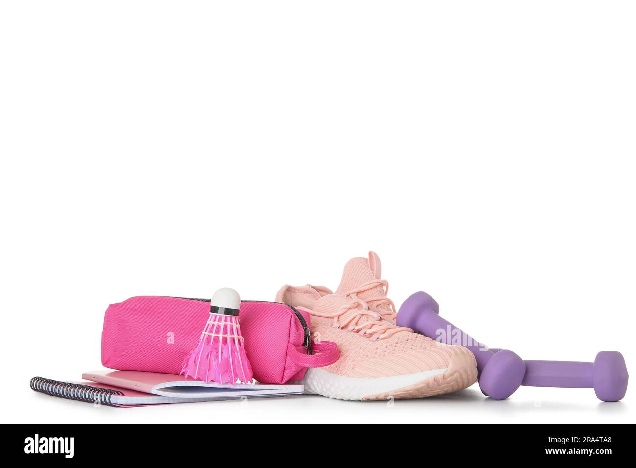 Sneaker mit Kurzhanteln, Badminton-Shuttle und Schreibwaren isoliert auf weißem Hintergrund Stockfoto