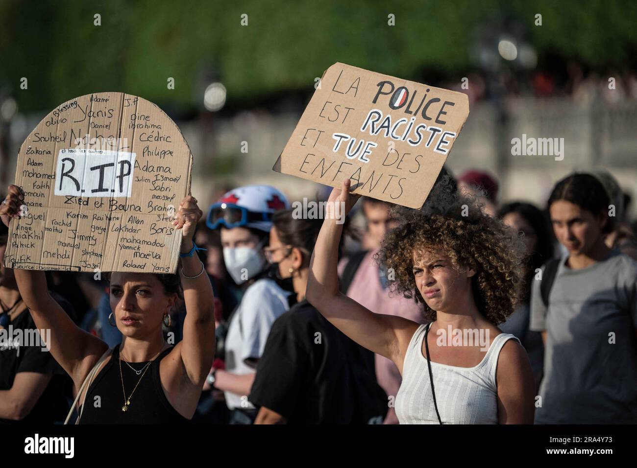 Paris, Frankreich. 30. Juni 2023. Eine Frau trägt ein Plakat mit der Aufschrift "Police are rassisist and kill children" während eines Protests in Paris, Frankreich, Freitag, den 30. Juni 2023. Der französische Innenminister sagt, dass es in einer vierten Nacht der Unruhen einen "Absturz" gegeben hat, mit 471 Verhaftungen im Vergleich zu 917 in der vorherigen Nacht. In mehreren französischen Städten wurde jedoch von weiteren Gewalttaten berichtet.die Unruhen begannen am Dienstag nach dem Polizeischuss auf einen 17-jährigen Jungen algerischer Abstammung namens Nahel M. der Beamte, der Nahel erschossen hat, entschuldigte sich bei der Familie, aber der Tod des Teenagers hat die Klagen wieder aufleben lassen Stockfoto