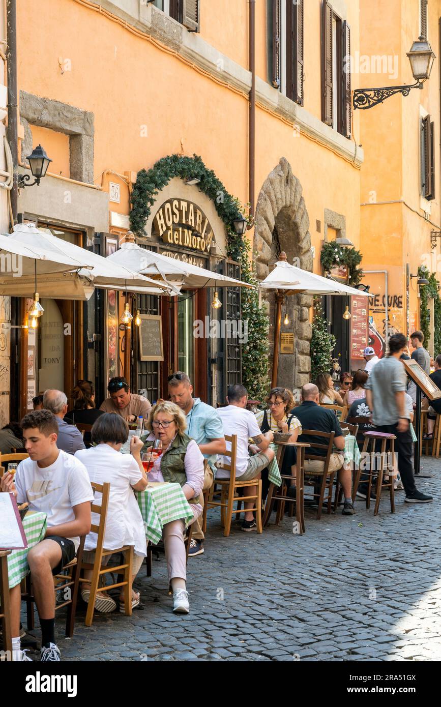 Malerisches Straßencafé-Restaurant in einer gepflasterten Straße, Rom, Latium, Italien Stockfoto