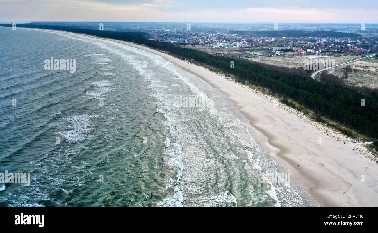 Luftaufnahme mit einem polnischen Dorf hinter dem Wald an der Ostsee in Polen Stockfoto