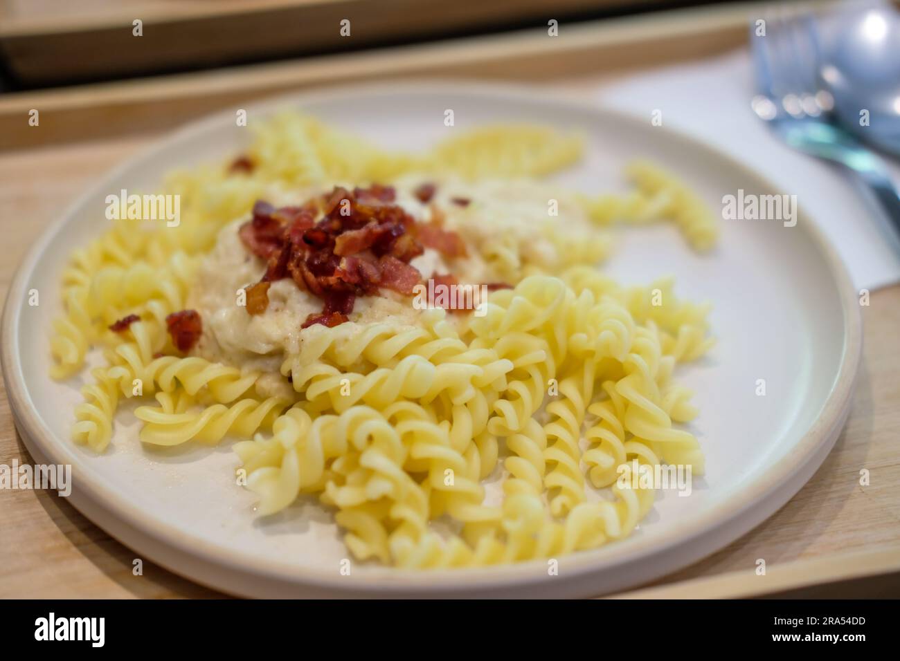Carbonara Fusilli Pasta mit knusprigem Speck auf dem Teller Stockfoto