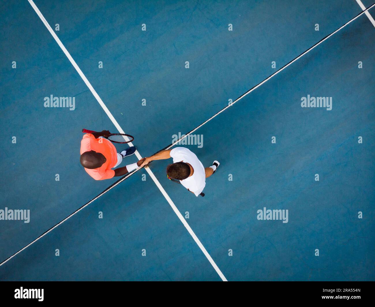 Blick von oben auf verschiedene männliche Tennisspieler, die sich die Hände auf dem Platz im Freien schütteln, Kopierbereich Stockfoto