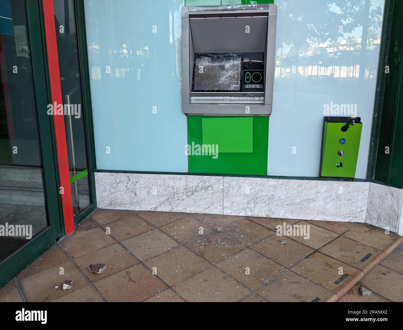 Zerbrochenes Glas roter Bankautomat, horizontal Stockfoto