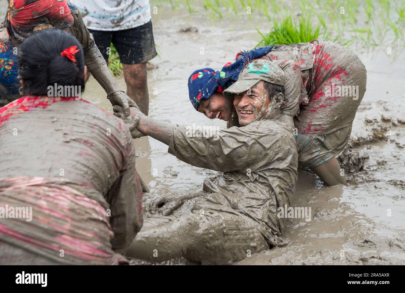 Kathmandu, Nepal. 30. Juni 2023. Während der National Paddy Day Party spielen die Menschen auf einem Reisfeld im schlammigen Wasser. Die nepalesische Bevölkerung feiert den National Paddy Day, indem sie Reisfelder anpflanzt, im Schlamm spielt, traditionelle Lieder singt, Joghurt isst und Reis schlägt, was den Beginn der jährlichen Reissaison markiert. Kredit: SOPA Images Limited/Alamy Live News Stockfoto