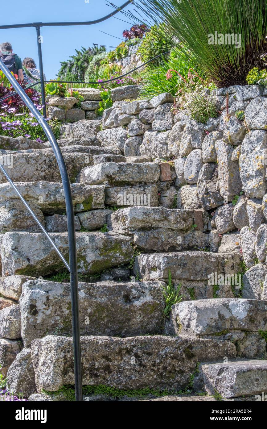 Zerklüftete, steile Steintreppen mit Steinwand und Geländer im Terrassengarten am St. Michael's Mount, Marazion, Cornwall, England, Großbritannien. Stockfoto