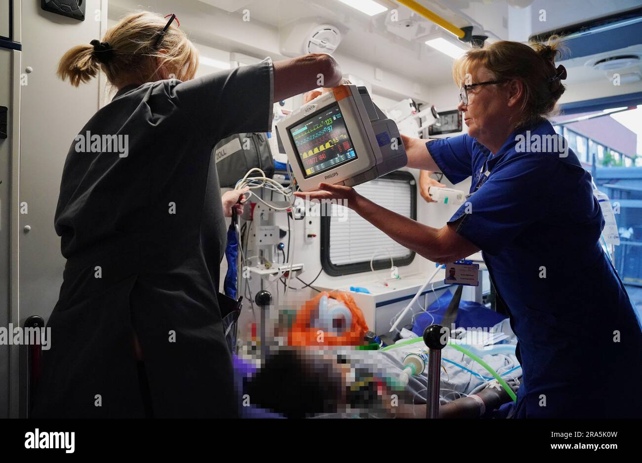 HERAUSGEBER VERMERKEN BILD VERPIXELT VON PA-BILDTISCH Advanced Nurse Practitioner Sarah Hardwick (links) neben Senior Staff Nurse Jayne Farrance (rechts) treffen Vorbereitungen, um zusammen mit ihrem jungen Patienten aus einem Krankenwagen auszusteigen, der von Sanitätern des South Thames Retrieval Service (STRS) betrieben wird, einem Intensivpflegedienst, Transport schwerkranker Kinder und Jugendlicher von örtlichen Krankenhäusern zu pädiatrischen Intensivstationen und Intensivstationen in der Region Süd-Themse mit speziell ausgerüsteten Krankenwagen. Foto: Freitag, 16. Juni 2023. Stockfoto