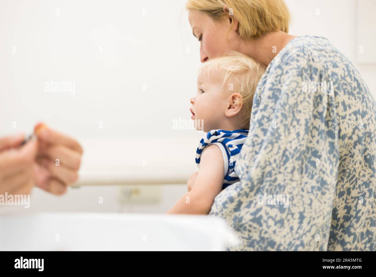 Kind, das von einem Kinderarzt in Gegenwart seiner Mutter geimpft wurde. Schutzimpfung gegen Diphtherie, Keuchhusten, Tetanus, Hepatitis, HAEM Stockfoto