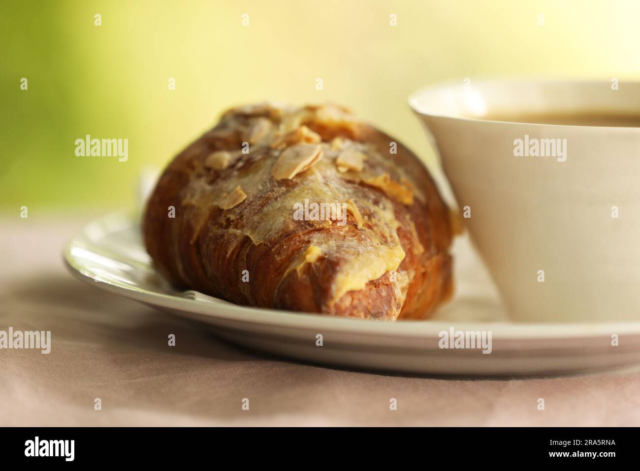 Ein Mandelcroissant und eine Tasse Kaffee Stockfoto