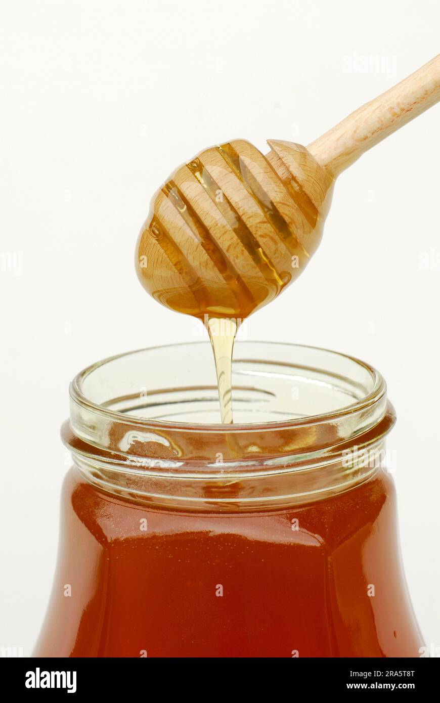 Honig im Glas mit Löffel, Honiglöffel Stockfoto