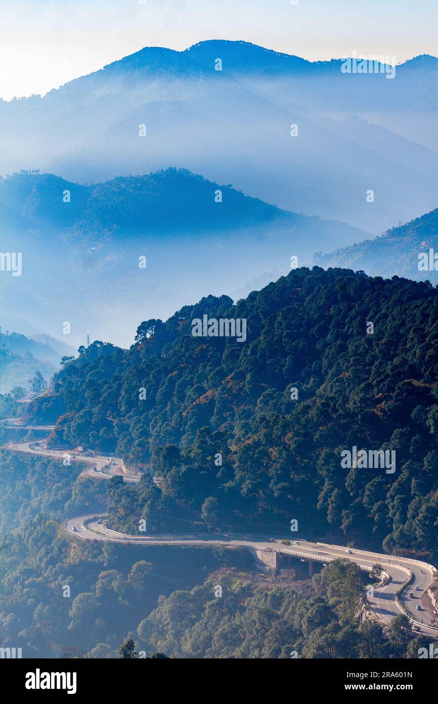 Wunderschöner Blick aus der Vogelperspektive auf eine lange kurvige Nationalstraße von Himachal Pradesh in Indien; Reisen Sie auf einer langen Straße mit landschaftlicher Schönheit und Sonnenschein Stockfoto