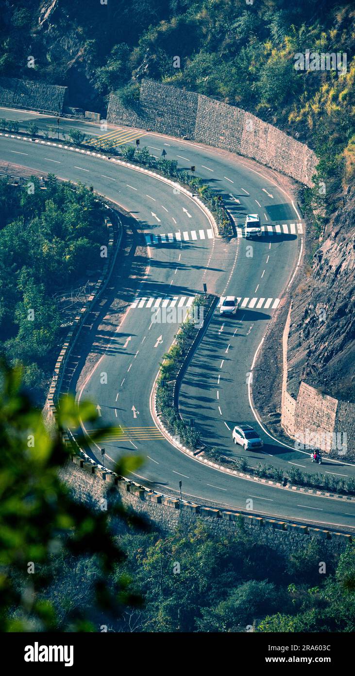 Wunderschöner Blick aus der Vogelperspektive auf eine lange kurvige Nationalstraße von Himachal Pradesh in Indien; Reisen Sie auf einer langen Straße mit landschaftlicher Schönheit und Sonnenschein Stockfoto