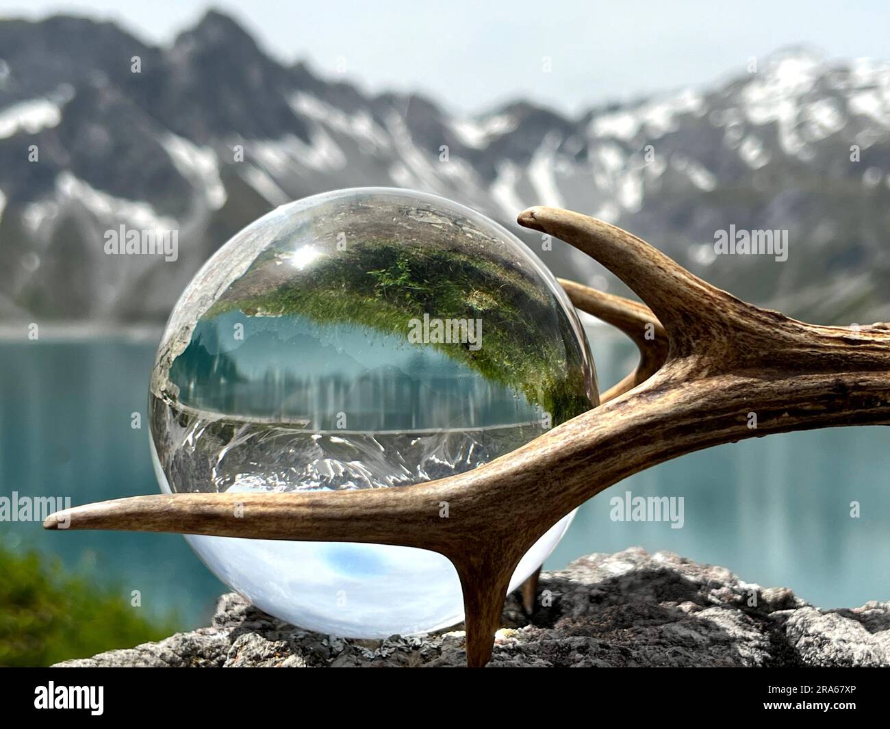 Röhrengeweih neben Linsenkugel, Kristallkugel, mit Reflexionen des Luenersee (Lünersee, Montafon, Vorarlberg). Stockfoto