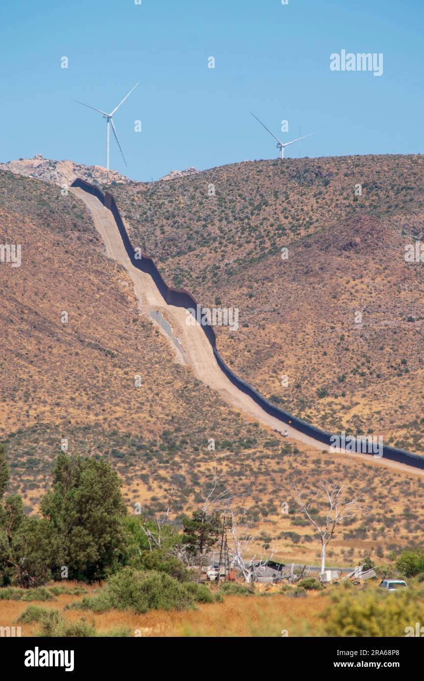 Die US-amerikanische Grenzmauer zu Mexiko verläuft durch die Landschaft und ist in Ocotillo, CA, kilometerweit zu sehen. Stockfoto