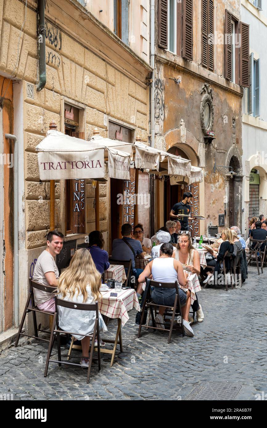 Malerischer Blick auf das Straßencafé-Restaurant in einer Kopfsteinpflasterstraße in Rom, Latium, Italien Stockfoto