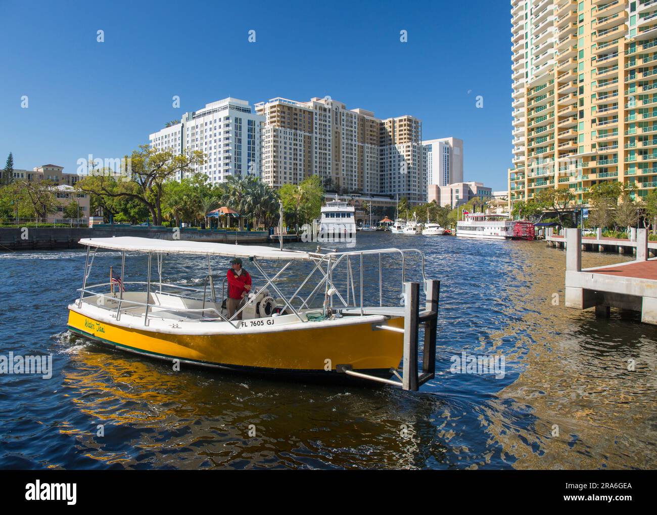 Fort Lauderdale, Florida, USA. Das Wassertaxi auf dem New River verlässt die Anlegestelle, die Hochhausarchitektur der Innenstadt im Hintergrund. Stockfoto
