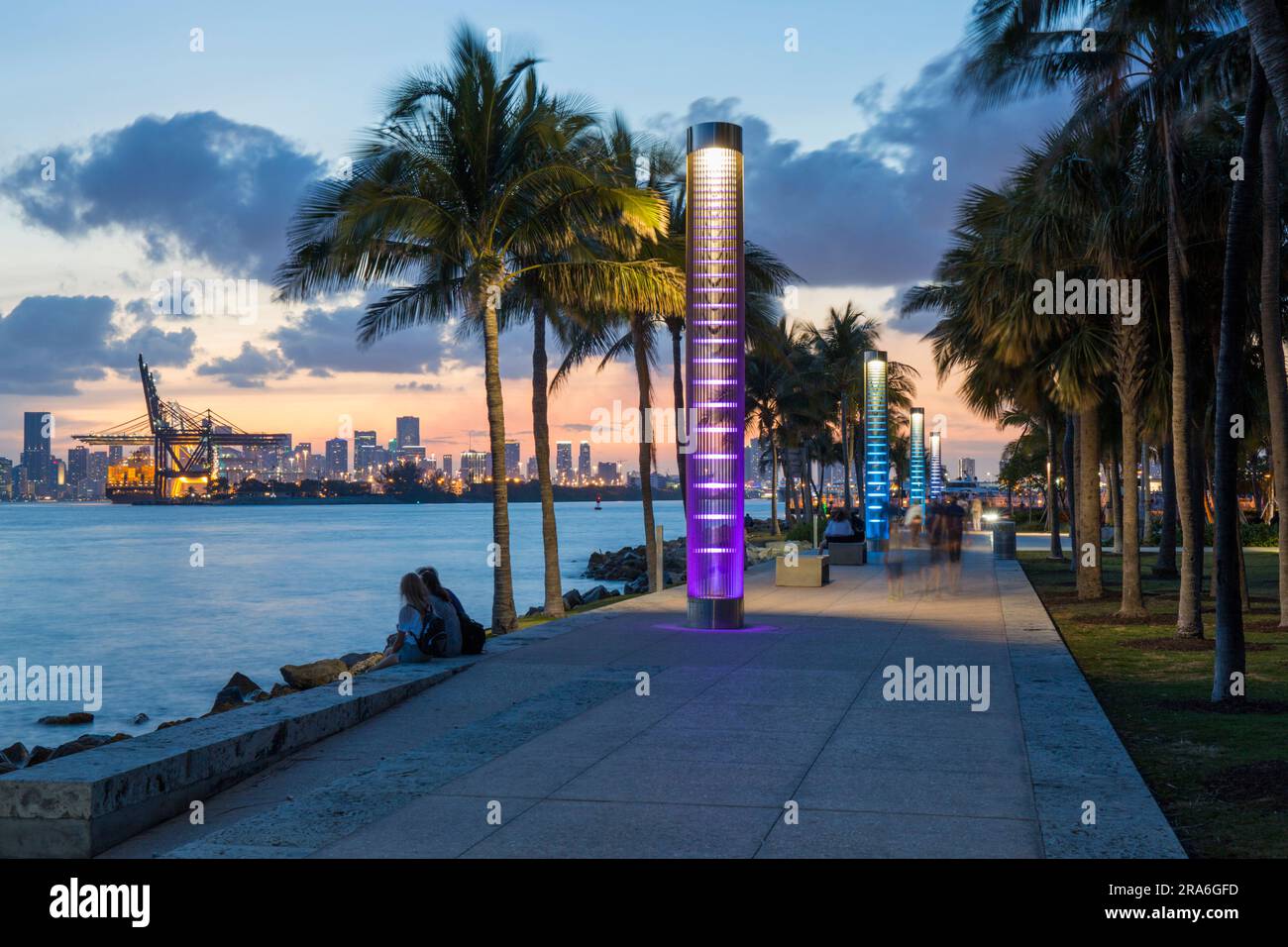 Miami Beach, Florida, USA. Blick auf den beleuchteten Fußweg im South Pointe Park, South Beach, Dämmerung, Downtown Miami im Hintergrund. Stockfoto