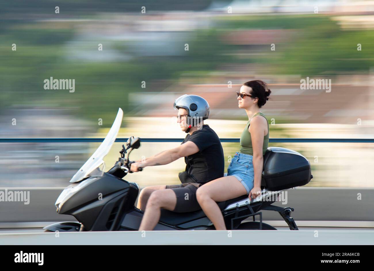 Belgrad, Serbien - 20. Mai 2023: Junger Mann, der an einem sonnigen Tag mit einer Sozius-Passagierin Motorrad fährt Stockfoto