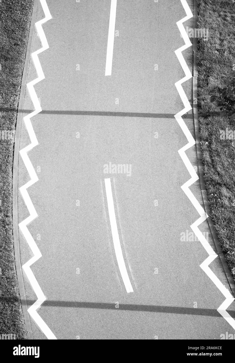 Straßenmarkierungen auf dem Fahrradweg durch den Park, von oben in Schwarz-Weiß Stockfoto
