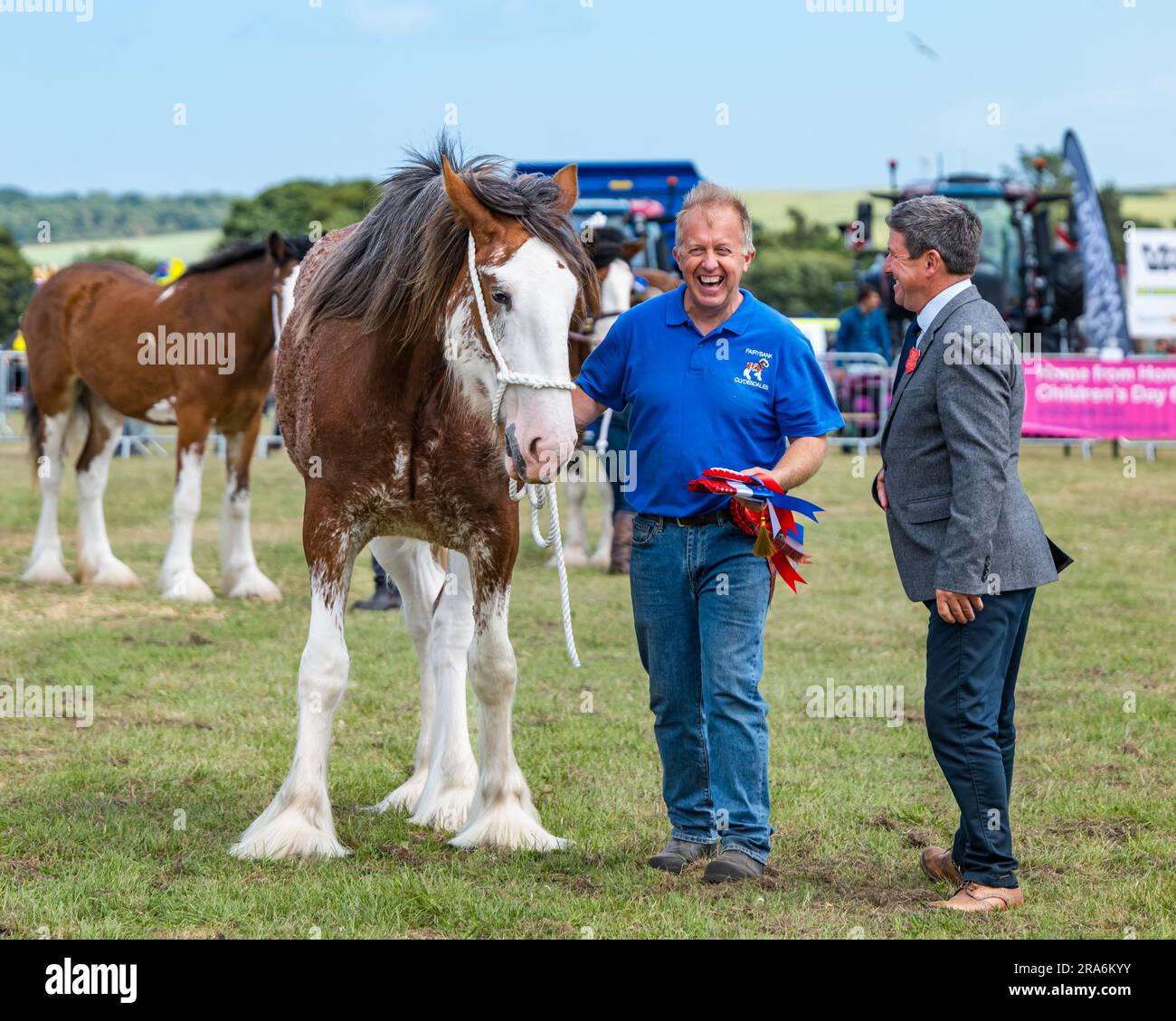 East Lothian, Schottland, Vereinigtes Königreich, 1. Juli 2023. Haddington Agricultural Show: Die Veranstaltung findet seit 1804 statt. Die Teilnehmer genossen einen sonnigen Tag. Im Bild: Die schweren Pferde, die mit einem sehr glücklichen Besitzer einer Clydesdale-Pferderosetten zu urteilen. Kredit: Sally Anderson/Alamy Live News Stockfoto