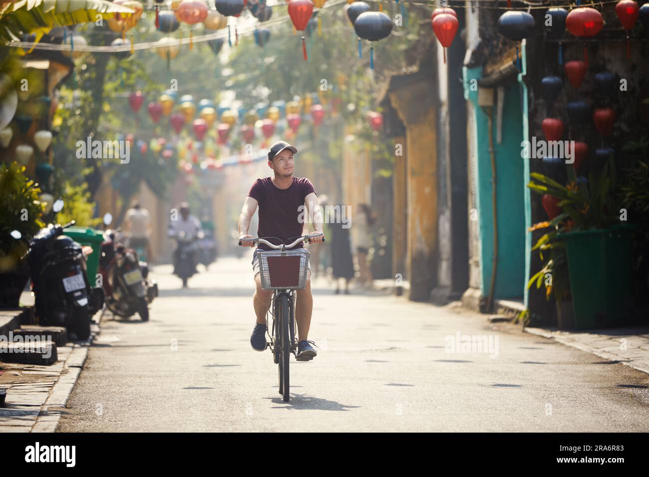 Touristenrad in der Altstadt. Straße der antiken Stadt, dekoriert mit traditionellen Laternen, Hoi an, Vietnam. Stockfoto