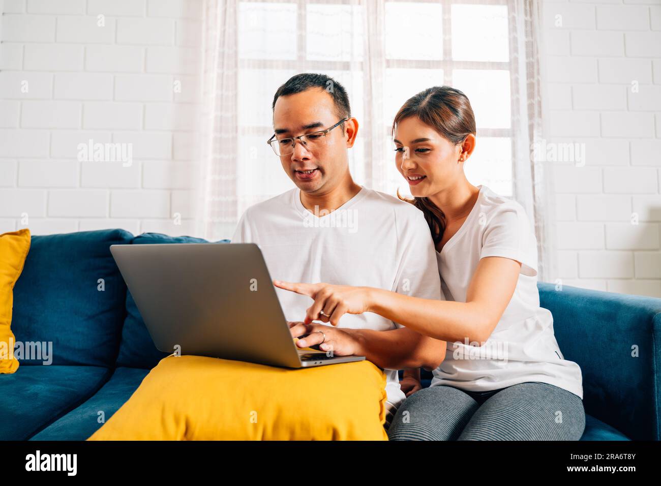 Ein Paar von Mann und Frau benutzte ein Notebook und surfte im Wohnzimmer im Internet Stockfoto