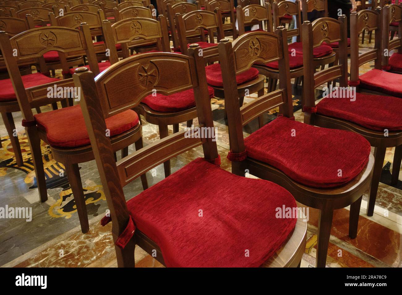 Holzstühle mit maltesischem Kreuz im Inneren von St. John's Co-Cathedral in Valletta, Malta Stockfoto