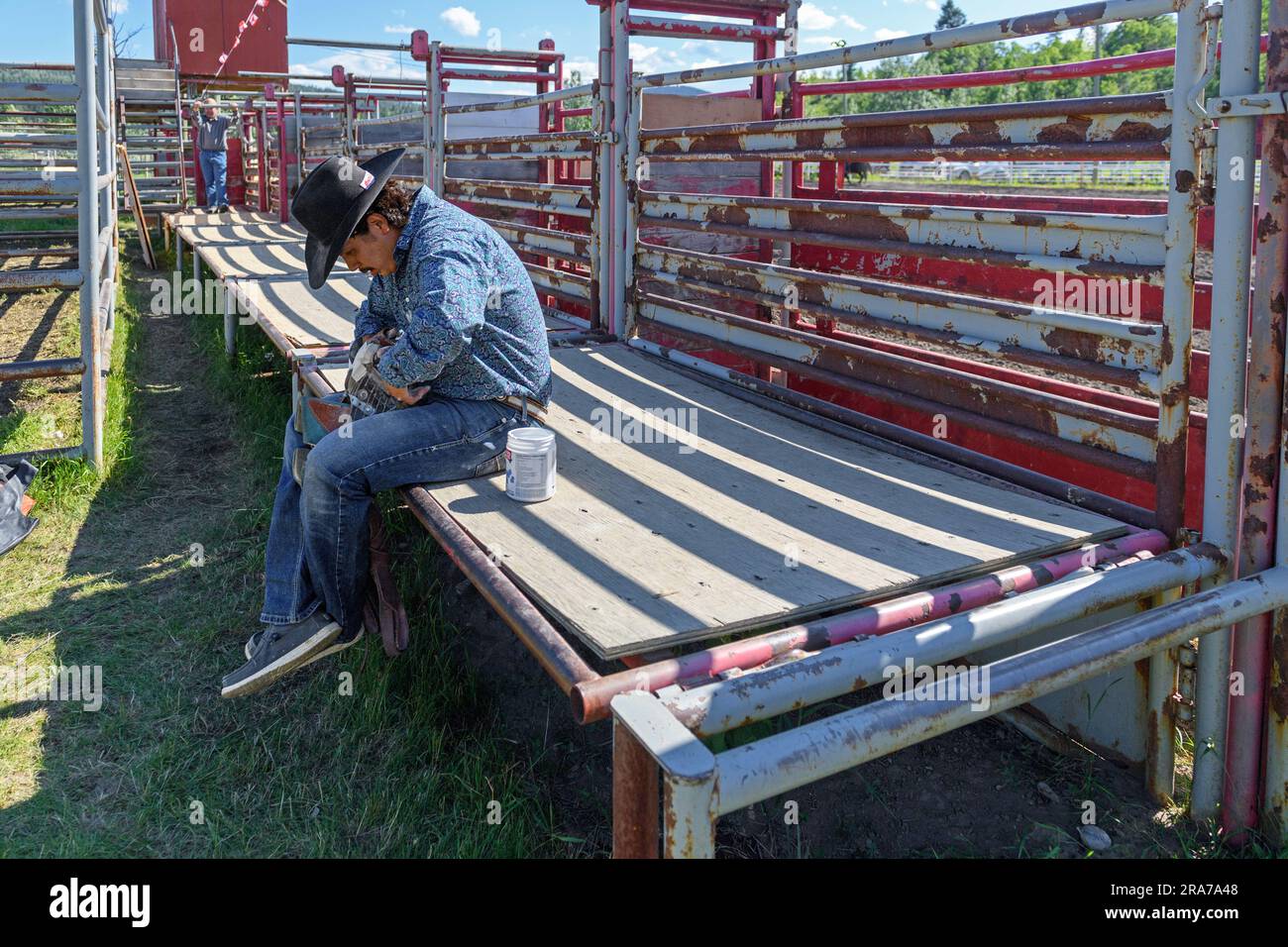 Einheimischer Cowboy, der sich vor dem Mini Thini Indian Rodeo, Chiniki Rodeo Grounds, in Stoney Nation Morley, Alberta, Kanada, vorbereitet Stockfoto