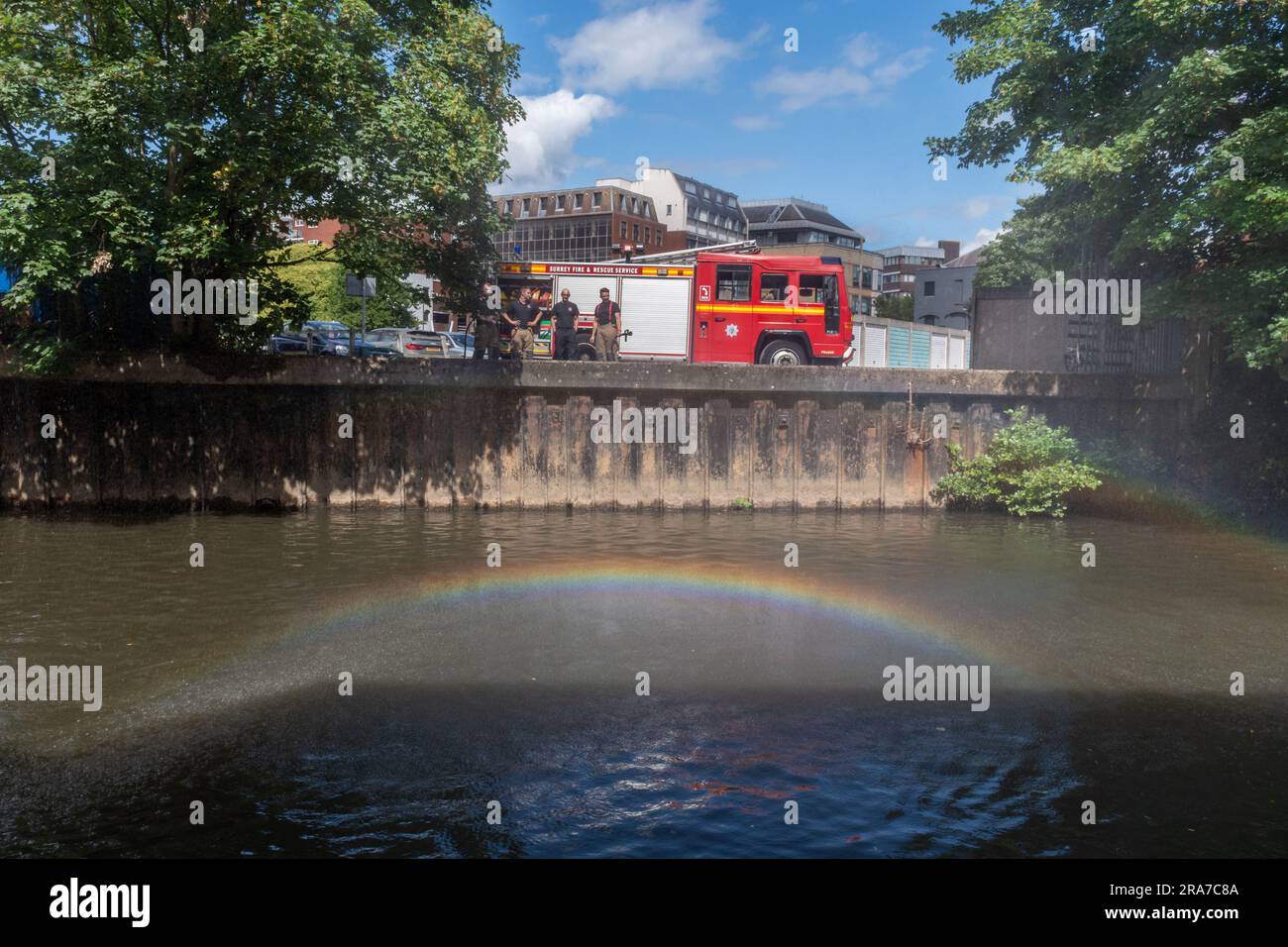 1. Juli 2023. Das jährliche Guildford Floß-Rennen auf dem River Wey, mit einem Surrey Feuerwehrauto und Regenbogen über dem Fluss, England, Großbritannien Stockfoto