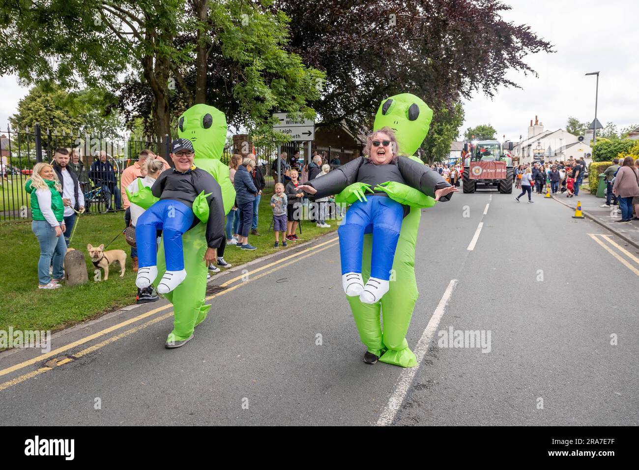 Juli 2023 - Croft Carnival Parade durch das Dorf. Mann und Frau in aufblasbaren Alien-Kostümen Stockfoto