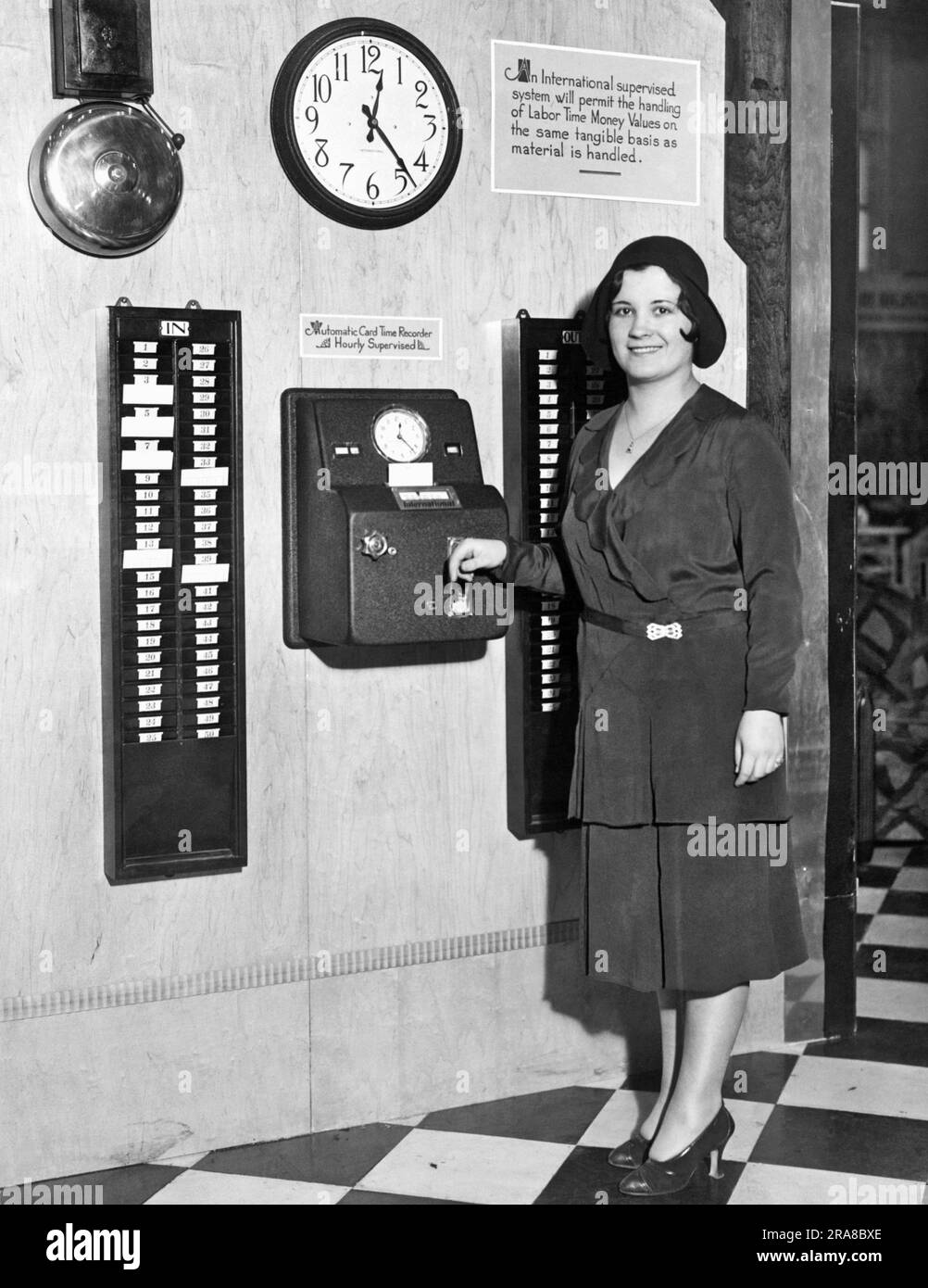 New York, New York: c. 1931 Eine Frau Probiert auf der National Business Show den neuen automatischen Card Time Recorder aus. Es ist eine der neuesten Ideen zur Unternehmenseffizienz. Stockfoto
