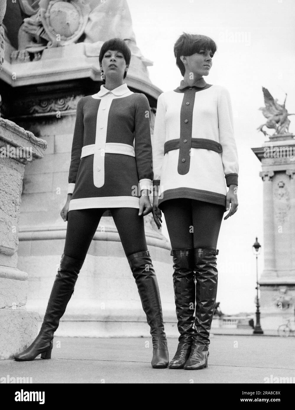 Vereinigte Staaten: 1969 zwei Frauen modellieren gegenläufige Outfits und hoch geschnittene Stiefel. Stockfoto