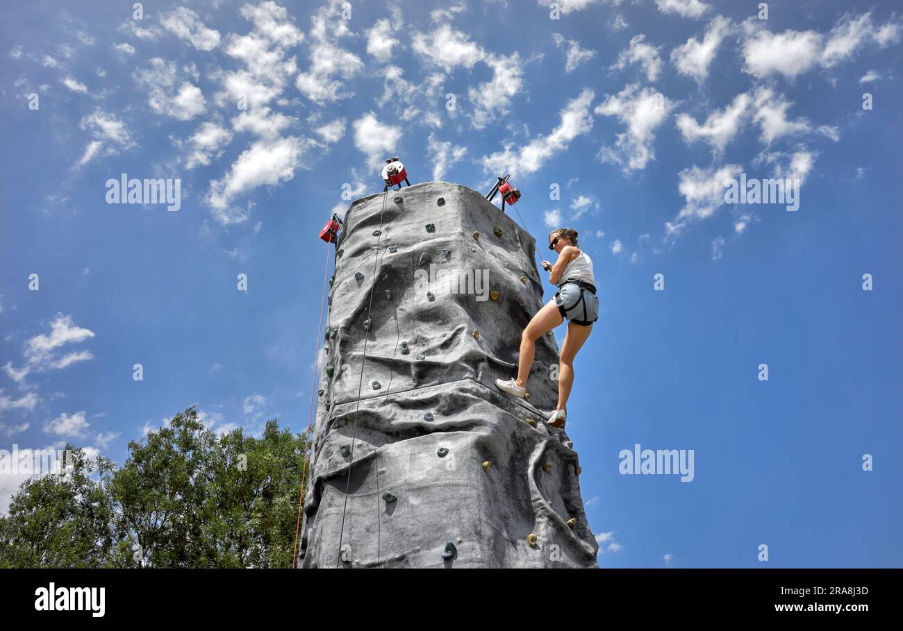 Woman Rock klettert vor dem Sommerhimmel auf eine künstliche Wand. England Großbritannien Stockfoto