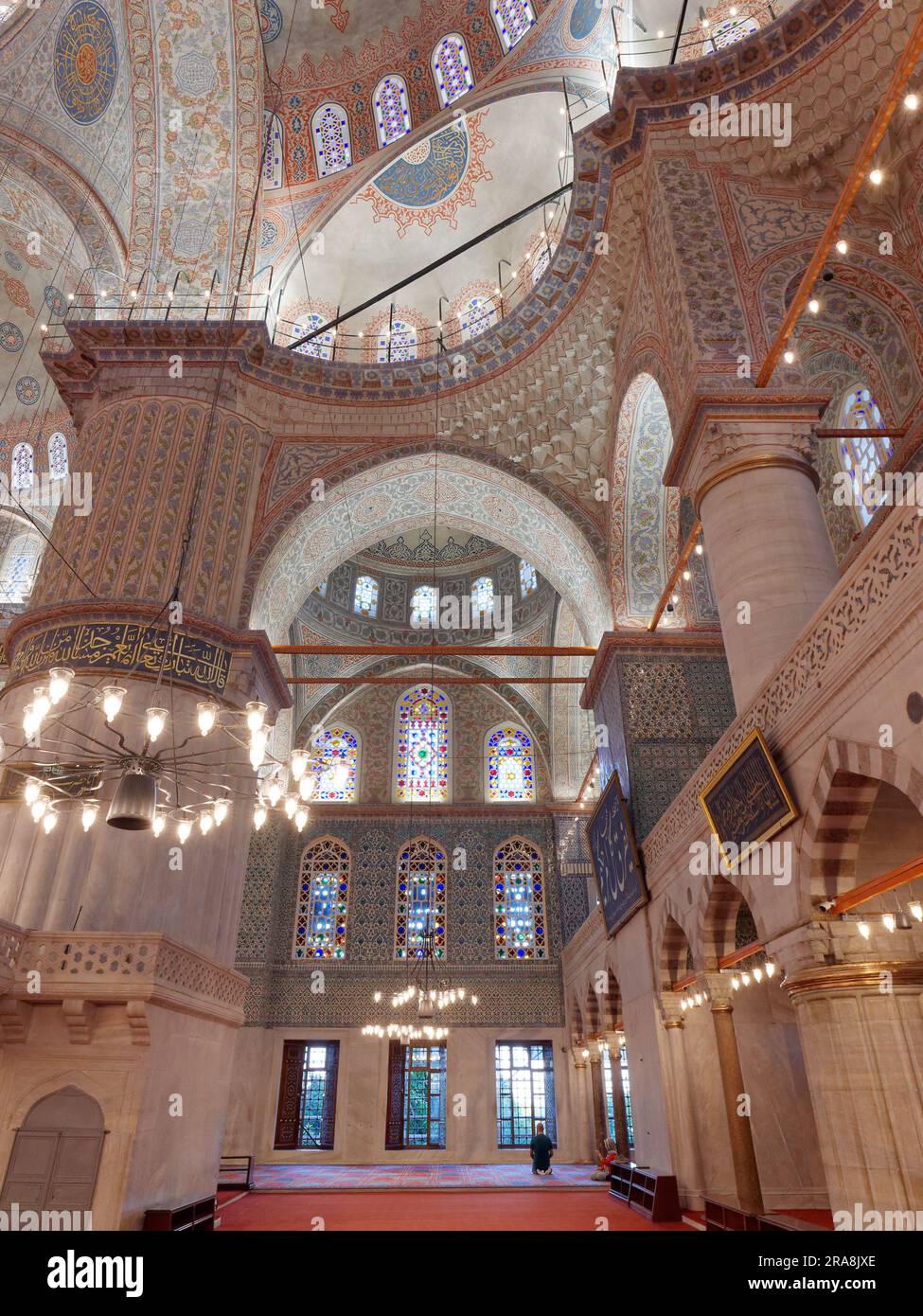 Sultan Ahmed aka Blaue Moschee im Inneren, Sultanahmet, Istanbul, Türkei. Ein Mann kniet im Gebet an der Front nieder Stockfoto