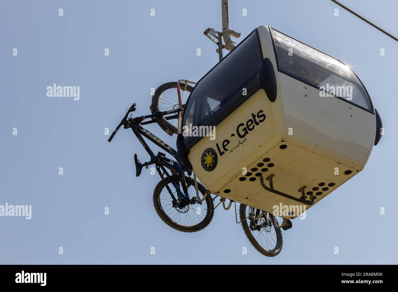 Seilbahn mit Geländefahrrädern über der französischen Alpenstadt Les Gets Stockfoto