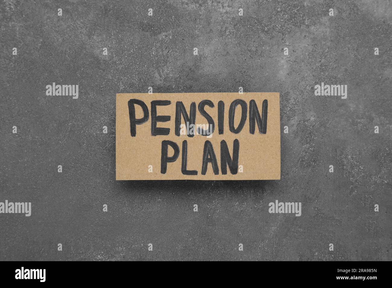 Karte mit den Worten Pensionsplan auf grauem Tisch, Draufsicht Stockfoto