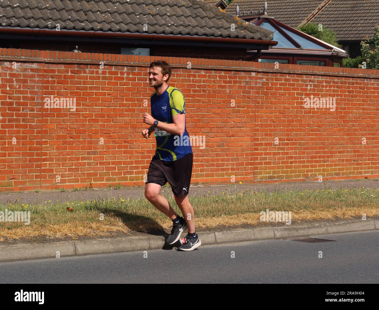 Kesgrave, Suffolk - 2. Juli 2023 : vom Laufverein Kesgrave Kruisers organisiertes Rennen zum Alan Brown Memorial 10k. Heißer Sommermorgen. Ein männlicher Läufer. Stockfoto